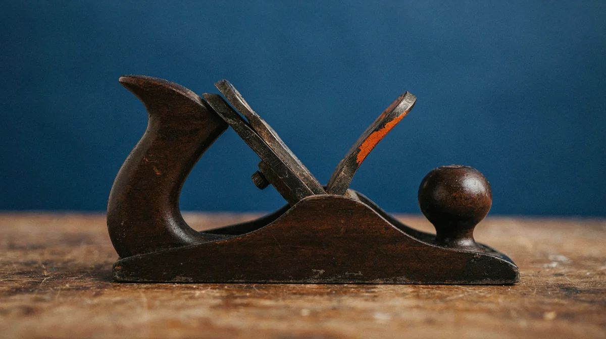 A well-worn hand plane tool on a workbench, representing the frontline user who does the real task today and knows exactly where it breaks